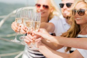 Girls tossing of glass of wine in Yacht Charter Party with bay experiences